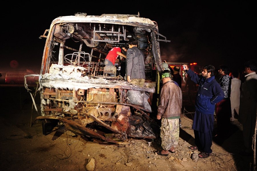 pakistani volunteers search for victims inside a burnt out passenger bus after it collided with an oil tanker along the super highway near karachi early on january 11 2015 photo afp