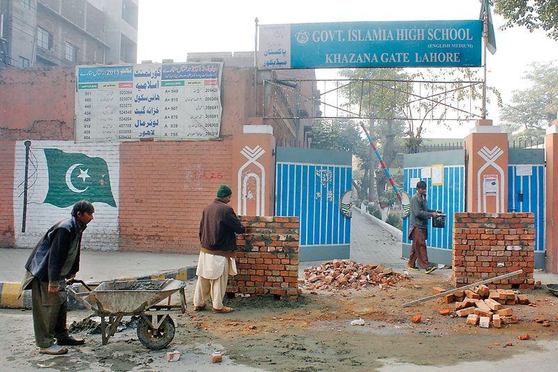 workers building obstacles in front of the entrance to government islamia high school khazana gate lower mall photo abid nawaz express