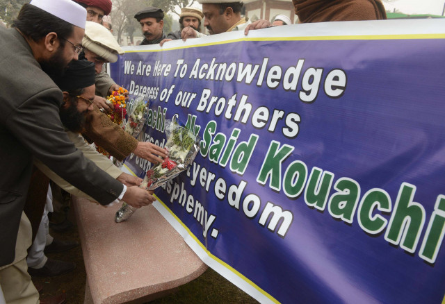 people place bouquets in front of a banner bearing the names of the two killed assailants who attacked french satirical weekly charlie hebdo in peshawar on january 13 2015 photo afp people place bouquets in front of a banner bearing the names of the two killed assailants who attacked french satirical weekly charlie hebdo in peshawar on january 13 2015 photo afp