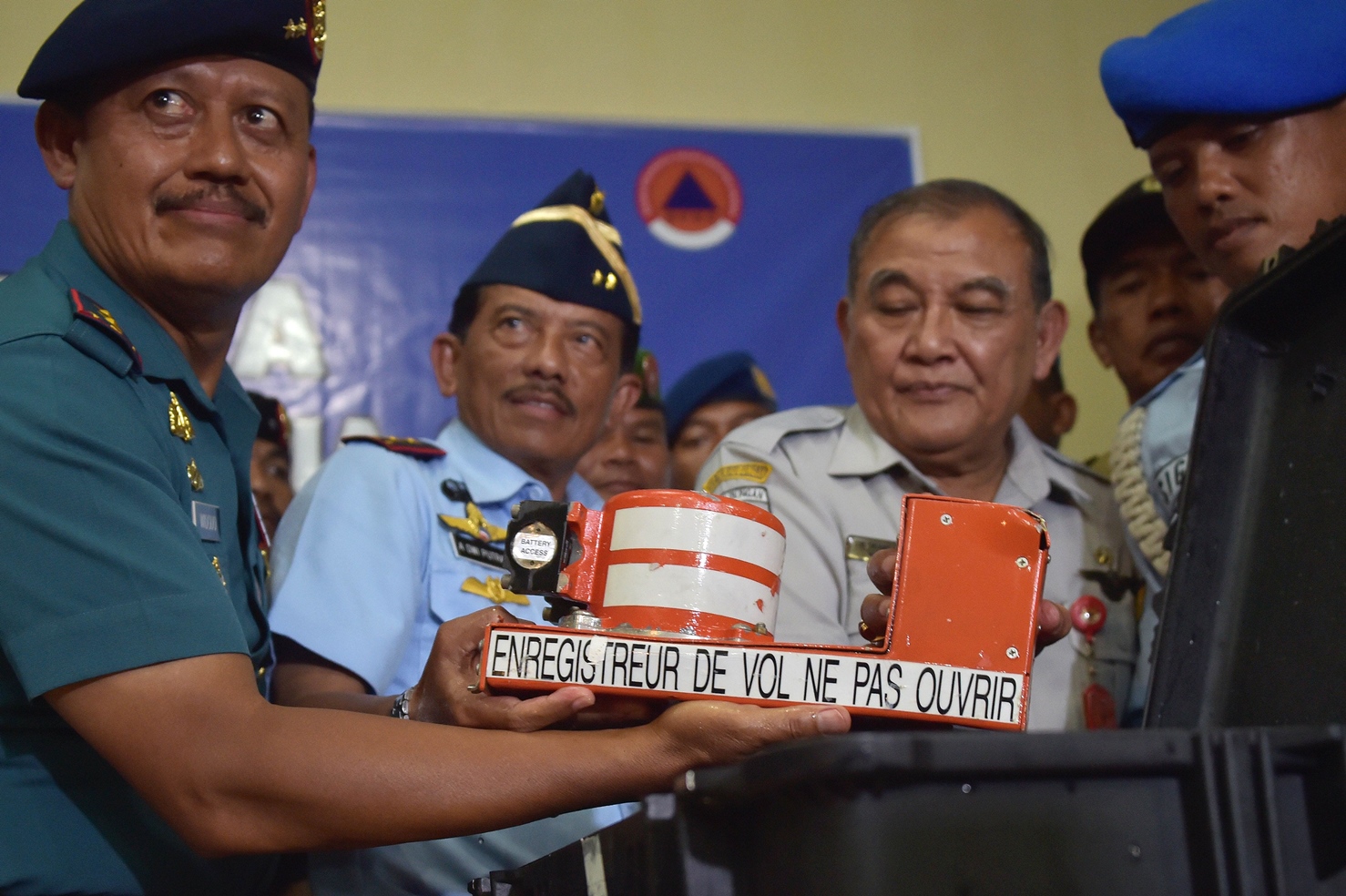 officials from indonesia 039 s military search and rescue task force and national transportation safety committee hold the cockpit voice recorder from airasia flight qz8501 upon its arrival on january 13 2015 photo afp