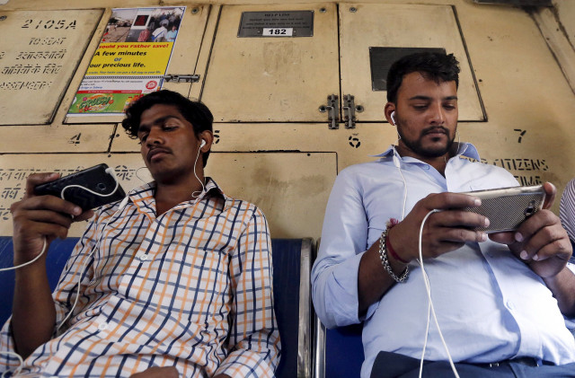 commuters watch videos on their mobile phones as they travel in a suburban train in mumbai india april 2 2016 photo reuters commuters watch videos on their mobile phones as they travel in a suburban train in mumbai india april 2 2016 photo reuters