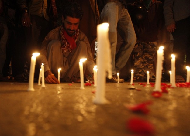 a man lights candles to mourn the victims from the army public school in peshawar photo reuters