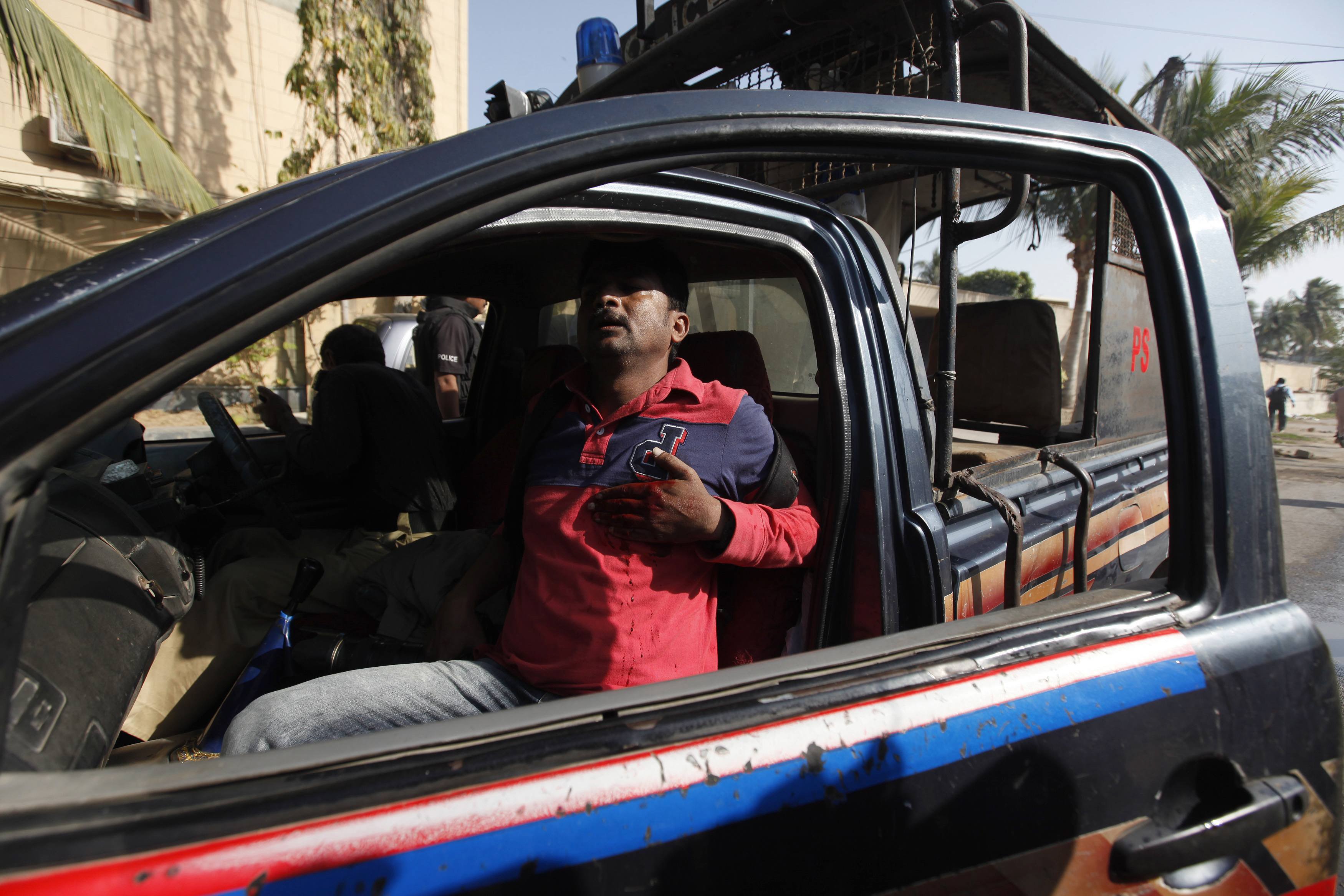 asif hassan a photographer of french news agency agence france press afp sits in a police vehicle with his hand on his chest after being shot during a protest against satirical french weekly charlie hebdo in karachi photo afp