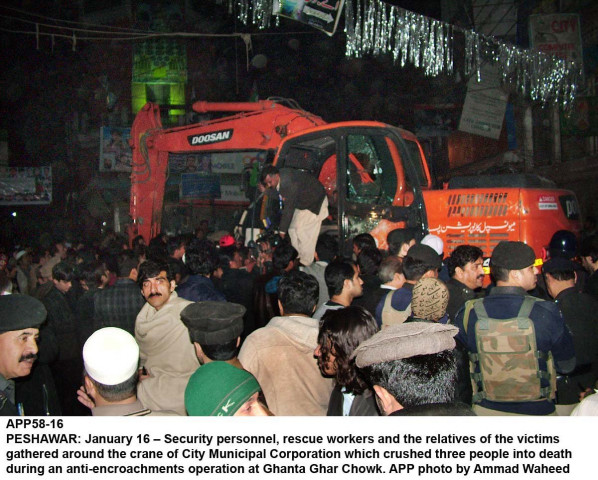 protesters and security officials gather near the excavator that crushed three labourers to death near ghanta ghar in peshawar photo app protesters and security officials gather near the excavator that crushed three labourers to death near ghanta ghar in peshawar photo app