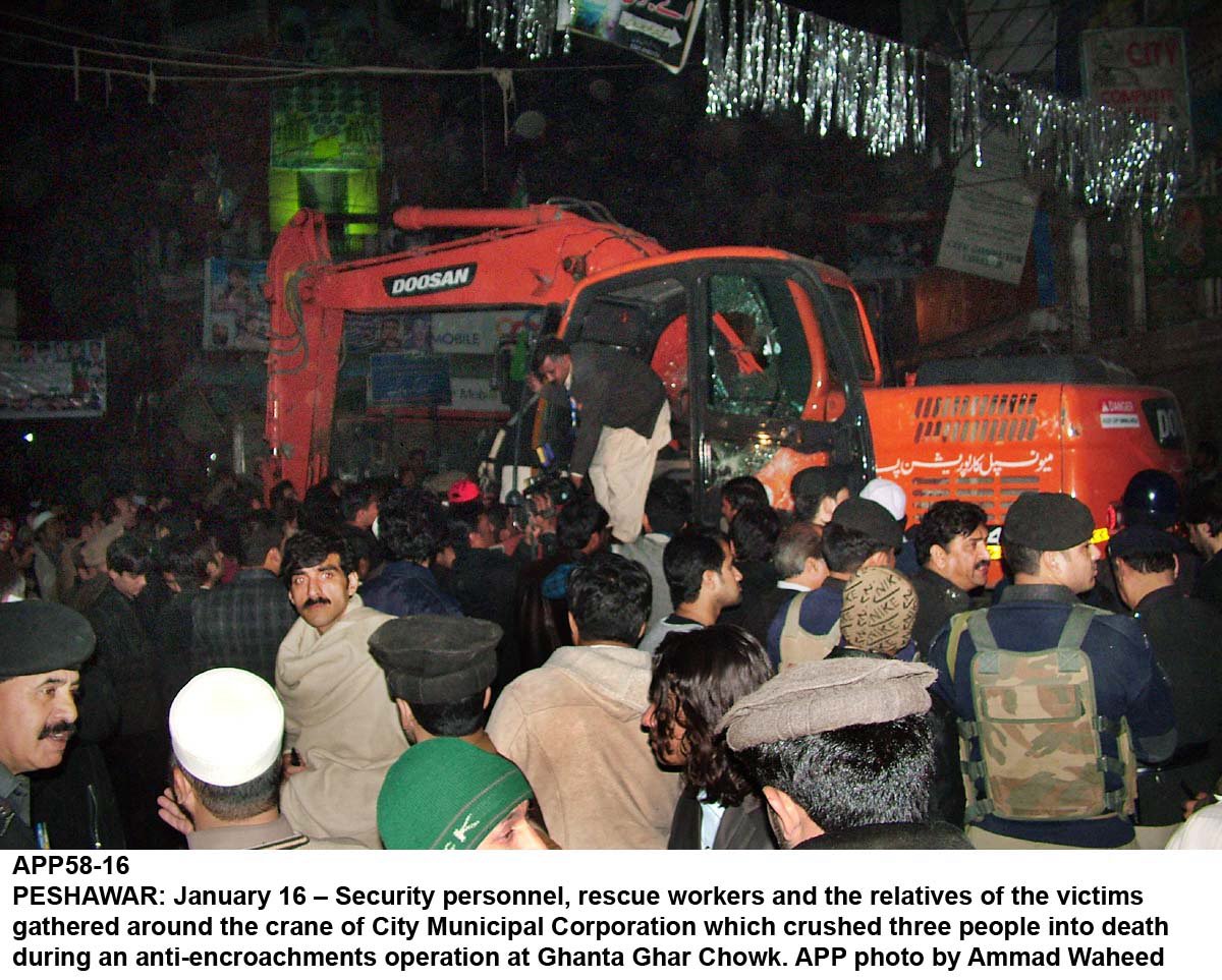 protesters and security officials gather near the excavator that crushed three labourers to death near ghanta ghar in peshawar photo app