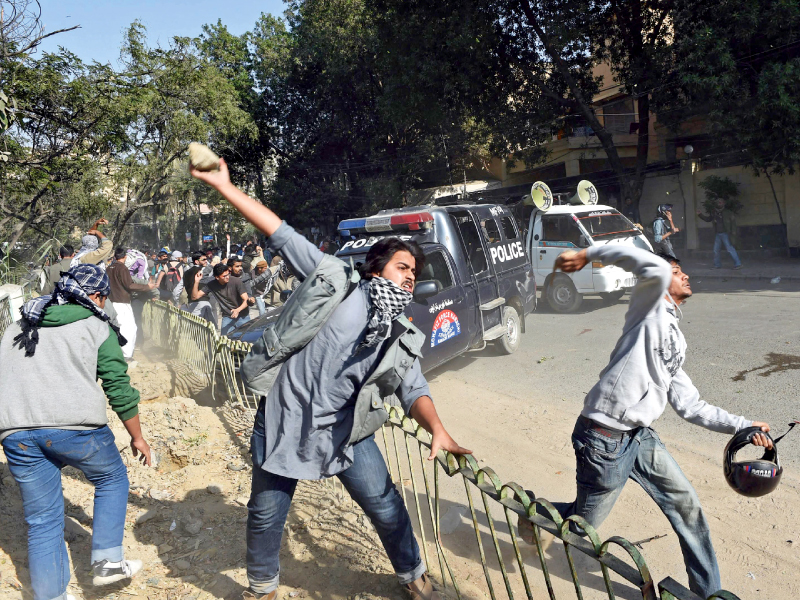 demonstrators throw stones at riot police during a protest in karachi photo afp