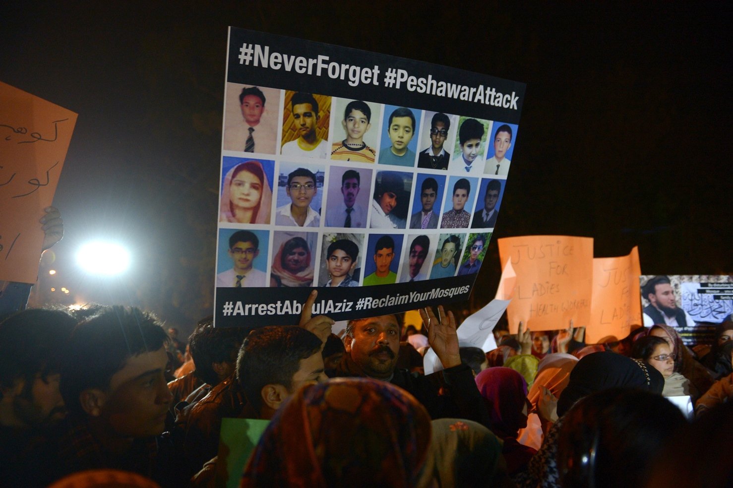 a protester carries a placard during a protest by civil society activists in islamabad featuring pictures of students who died in the peshawar school attack photo afp