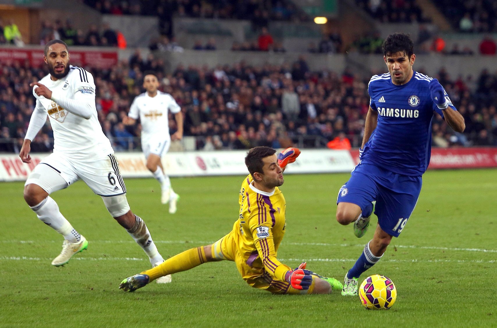 chelsea s brazilian born spanish striker diego costa r runs with the ball past swansea city s polish goalkeeper lukasz fabianski to score his team 039 s third goal during the english premier league football match between swansea city and chelsea at the liberty stadium in swansea south wales on january 17 2015 photo afp