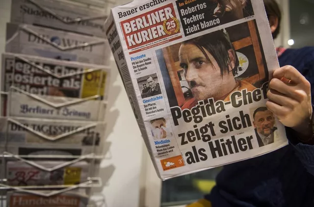 a woman reads a newspape carrying a picture of pegida leader lutz bachmann allegedly posing as hitler in berlin photo afp a woman reads a newspape carrying a picture of pegida leader lutz bachmann allegedly posing as hitler in berlin photo afp