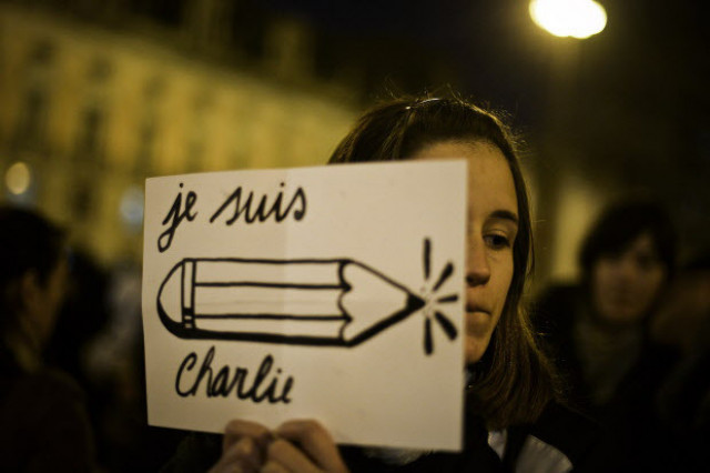 a young woman holds a poster reading je suis charlie i am charlie during a tribute for victims photo afp a young woman holds a poster reading je suis charlie i am charlie during a tribute for victims photo afp