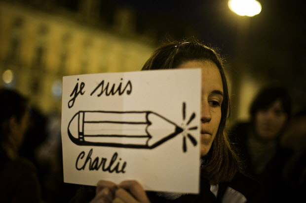 a young woman holds a poster reading je suis charlie i am charlie during a tribute for victims photo afp
