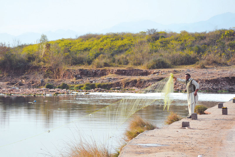 a man drops a net into the korang river photo huma chaudhary express