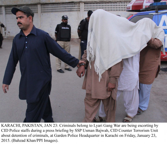 a police official leads off an alleged extortionist in karachi photo ppi a police official leads off an alleged extortionist in karachi photo ppi