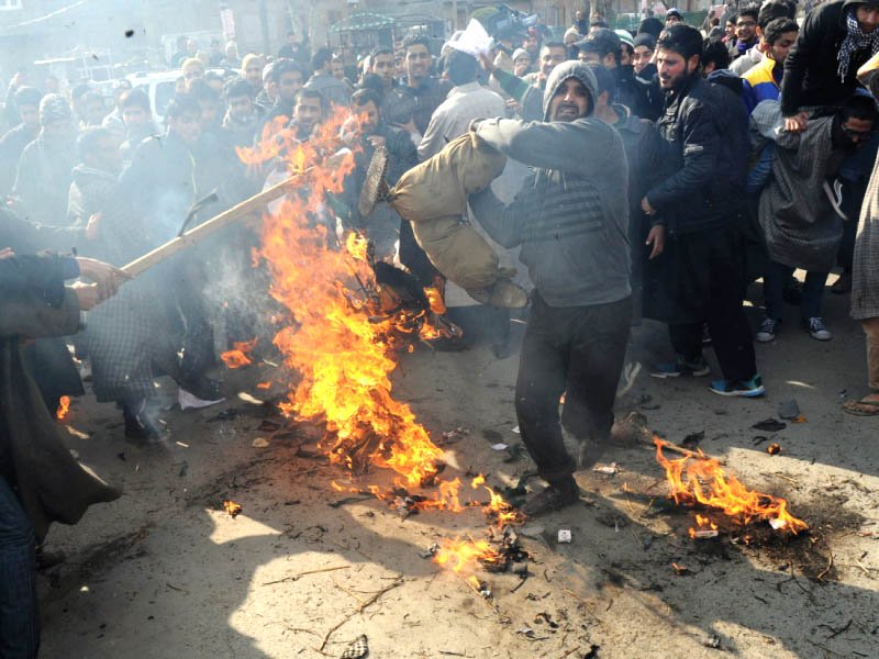 a protester beats a burning effigy representing charlie hebdo in srinagar photo afp