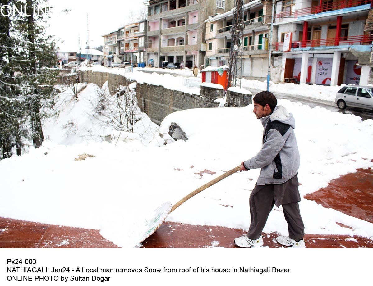 a local man removing snow from his roof photo online