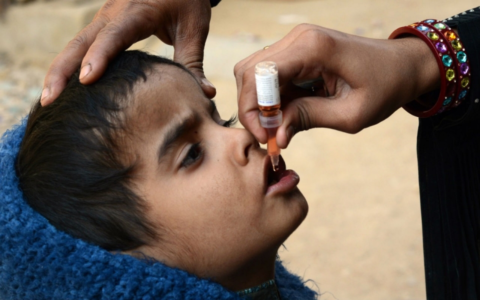 a health worker administers polio vaccine drops to a young child at a polio vaccination center photo afp