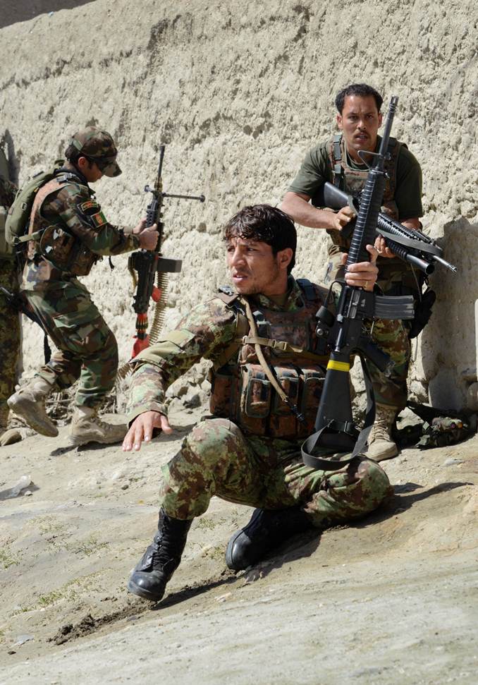 in this photograph taken on march 19 2014 afghan soldiers from the 4th brigade 201 army corps of the afghan national army ana take positions behind an adobe wall after being fired upon by insurgents during an operation in khogyani district photo afp