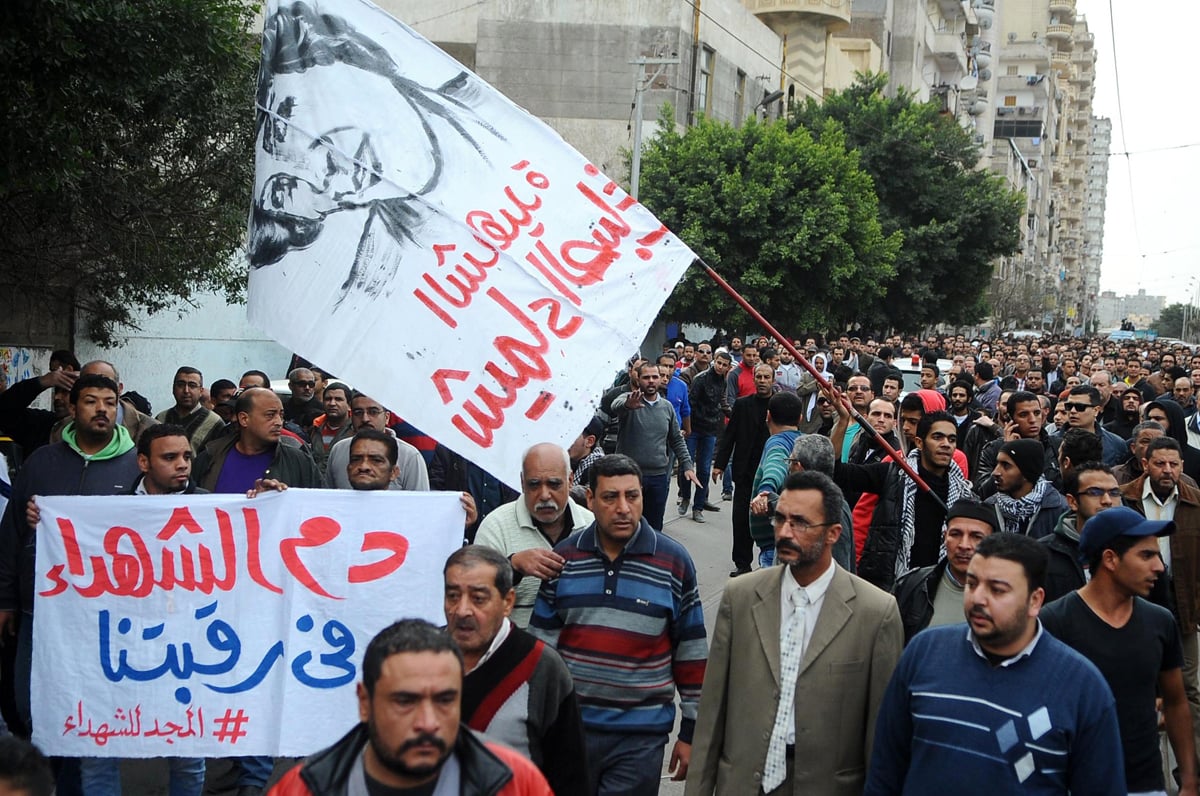 egyptians hold banners during the funeral procession of shaima al sabbagh an egyptian protester who was killed in clashes with the police on january 25 2015 in egypt 039 s second city alexandria photo afp