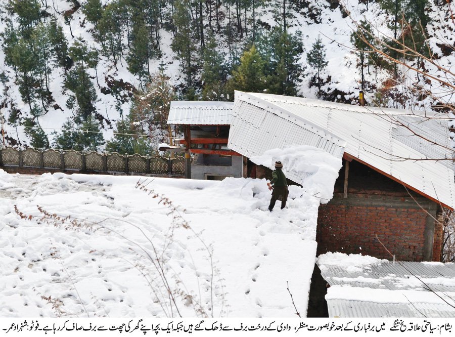 a boy shovels snow on a roof in yakh tangay in besham photo umar bacha express