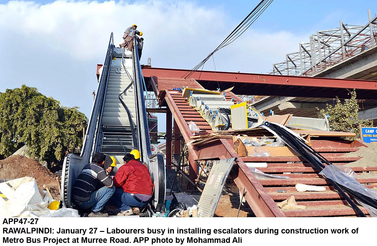 labourers busy installing escalators during construction of the metro bus project at murree road photo app labourers busy installing escalators during construction of the metro bus project at murree road photo app