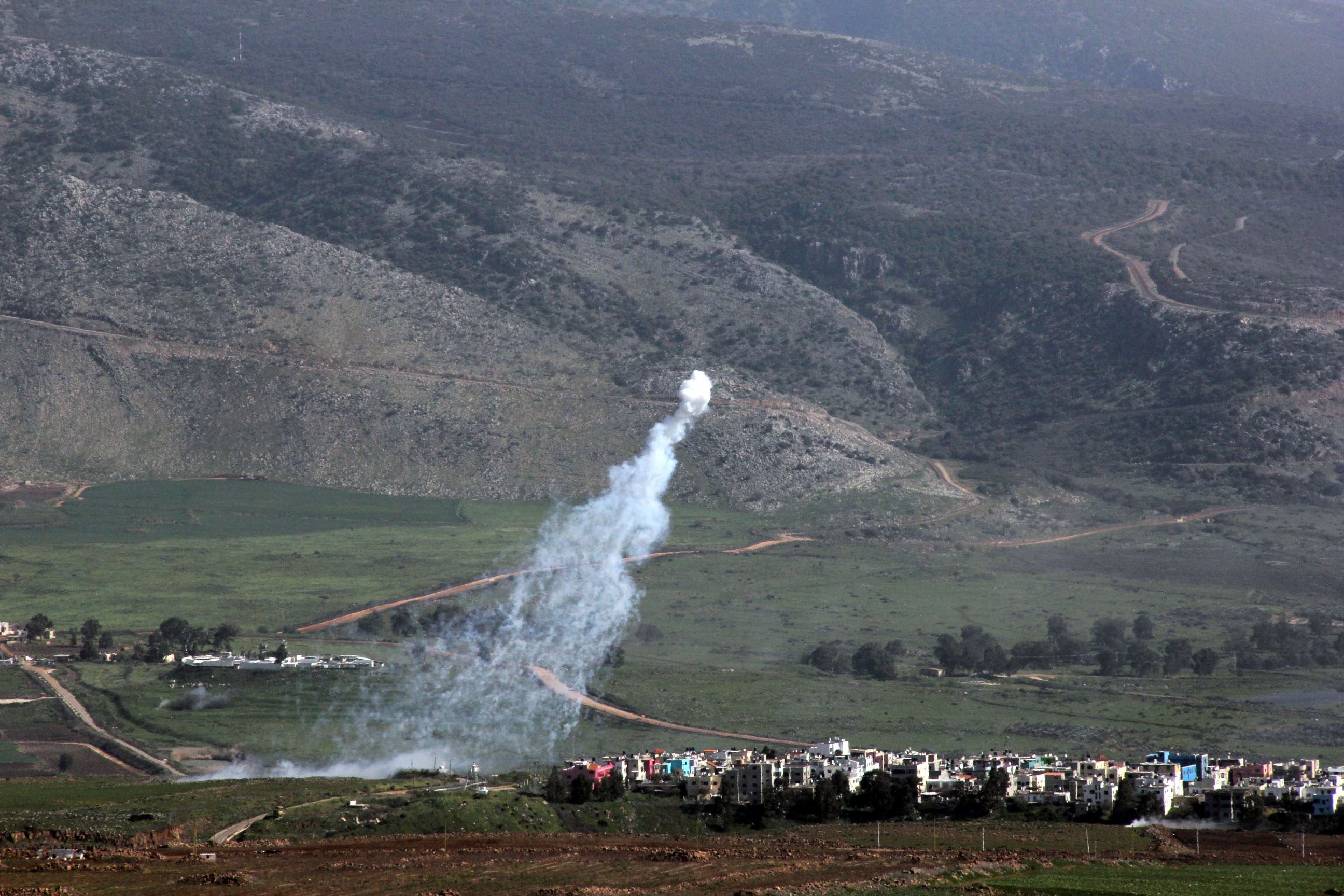 smoke from israeli shelling covers the lebanese town of al majidiyah l on the lebanese border with israel as the town of al ghajar is seen on the right on january 28 2015 photo afp