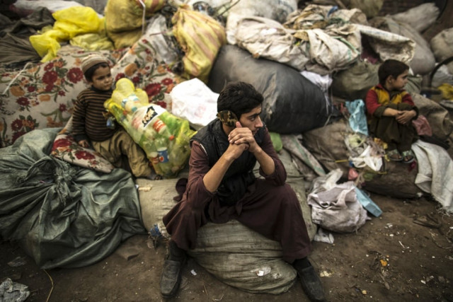 in this file photo afghan refugees sit on sacks filled with used plastic items to sell at their makeshift shelter in a slum on january 12 2015 photo reuters
