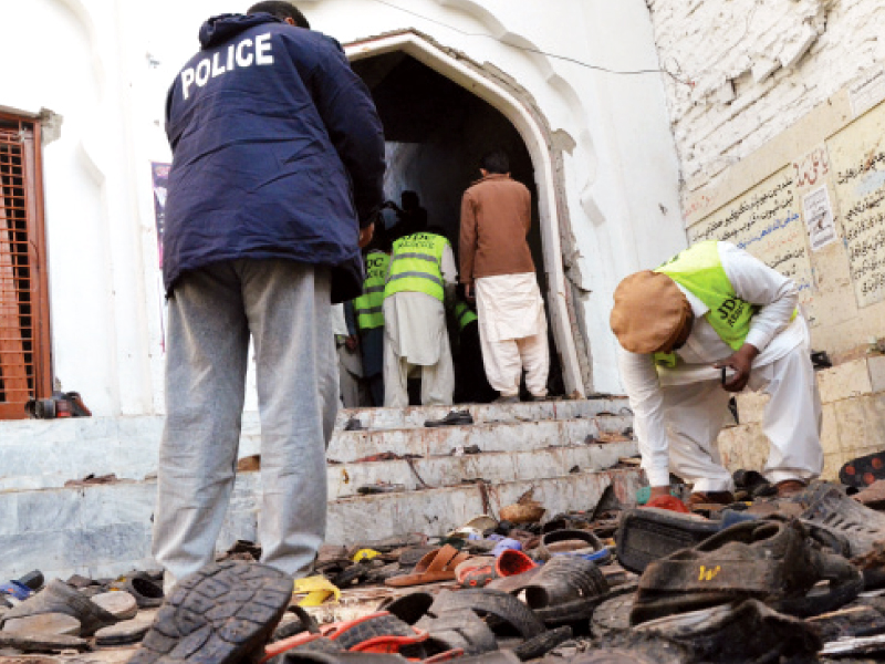 policemen and forensic experts examine the area outside karbala maula imambargah in shikarpur on friday afternoon when a bomb weighing nearly eight kilogrammes went off during the weekly sermon most of the injured were rushed to private hospitals in sukkur and larkana as the government facilities struggled to tend to the victims photo afp