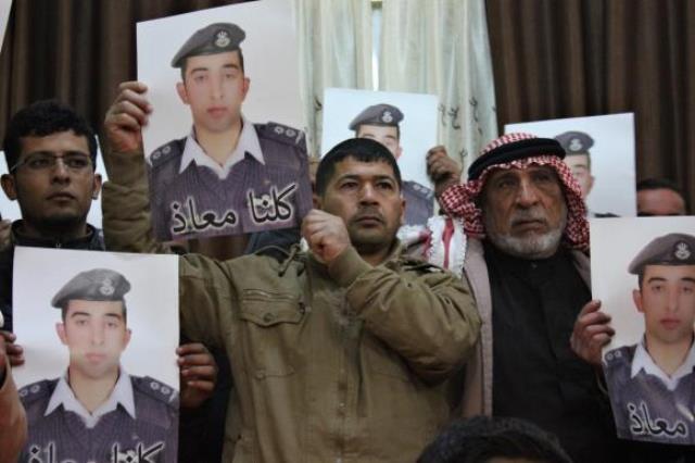 relatives of is captive jordanian pilot muath al kasaesbeh hold his poster as they take part in a rally in his support at the family 039 s headquarters in the city of karak photo reuters