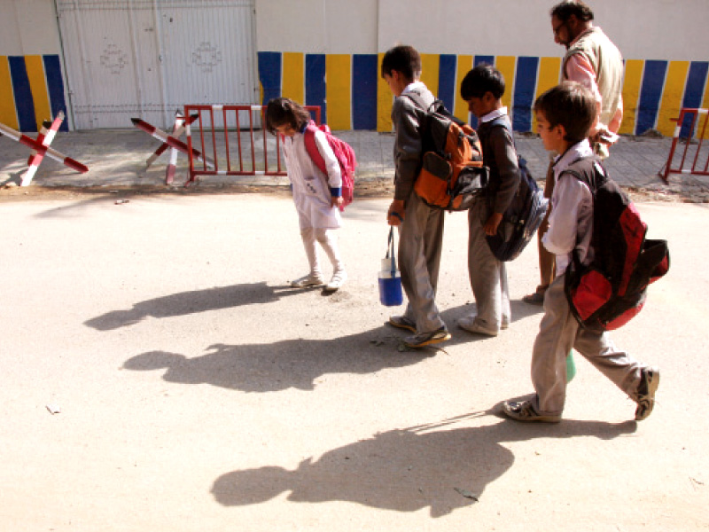 students walk outside beacon light academy where two grenades were hurled on tuesday photo athar khan express