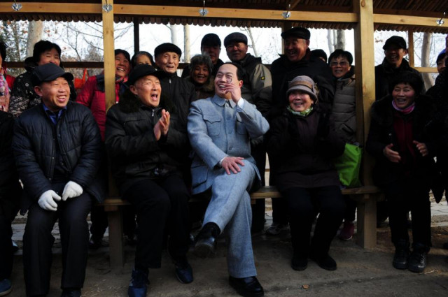 xu ruilin who is constantly working on his dialect and calligraphy to better imitate communist china 039 s founding father mao zedong poses with a group of admirers in his hometown in shandong province photo afp