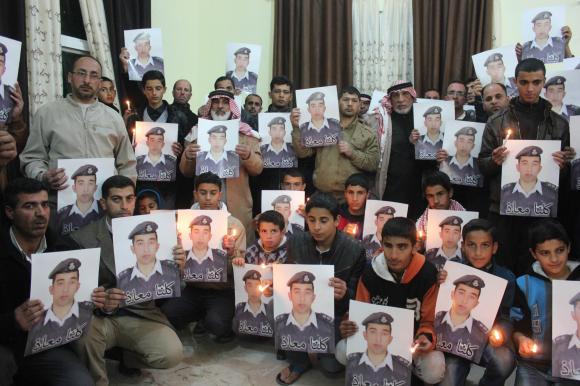 relatives of islamic state captive jordanian pilot muath al kasaesbeh hold his portrait as they take part in a rally in his support at the family 039 s headquarters in the city of karak photo reuters