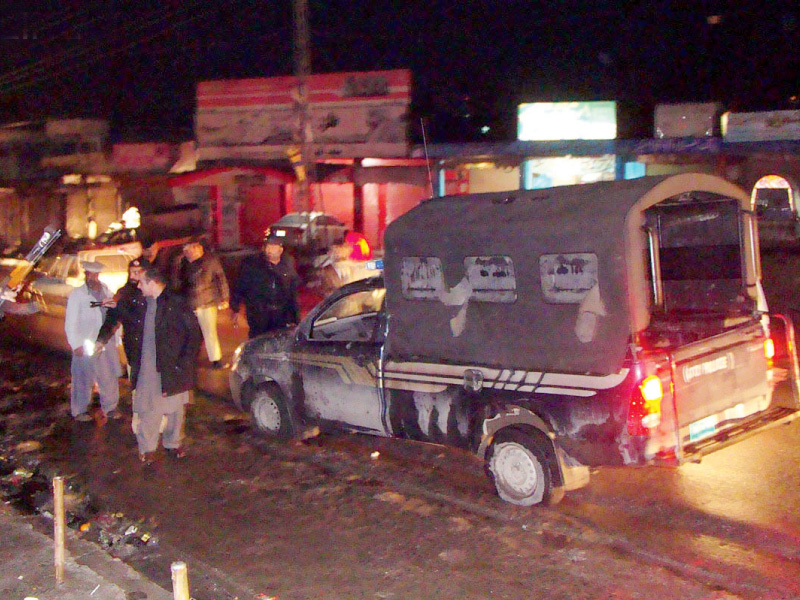 security officials gather near the police van after it came under attack in mansehra photo online
