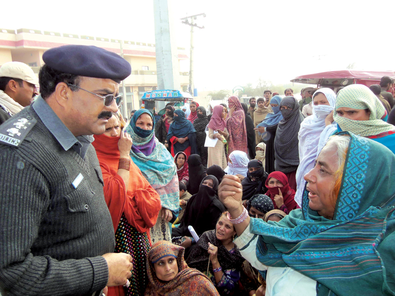 a woman talks to a policeman as he urges protesters to clear quetta road and allow traffic to pass photo express
