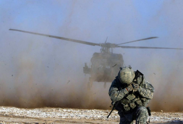 a soldier protects his face from helicopter dust during a mission by us forces in an area some 100 kilometres south of kirkuk iraq on december 24 2010 photo afp a soldier protects his face from helicopter dust during a mission by us forces in an area some 100 kilometres south of kirkuk iraq on december 24 2010 photo afp