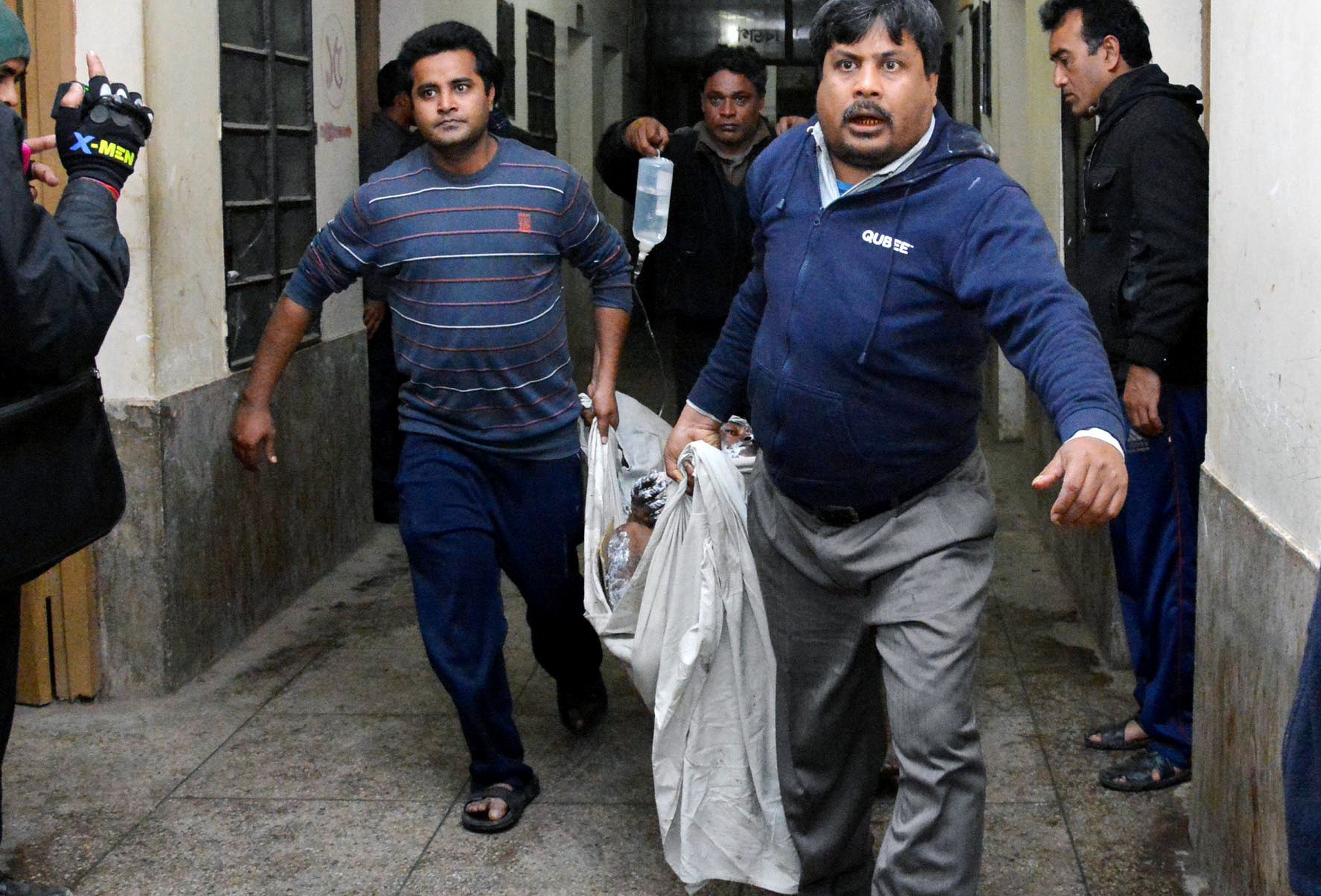 people carry a man who suffered burn injuries after a petrol bomb attack on a bus on gaibandha some 285 km from dhaka on february 7 2015 during an ongoing blockade called by the bangladesh nationalist party bnp  led alliance four people including a child have been killed and 30 others burnt in a petrol bomb attack on a bus escorted by police in gaibandha photo afp