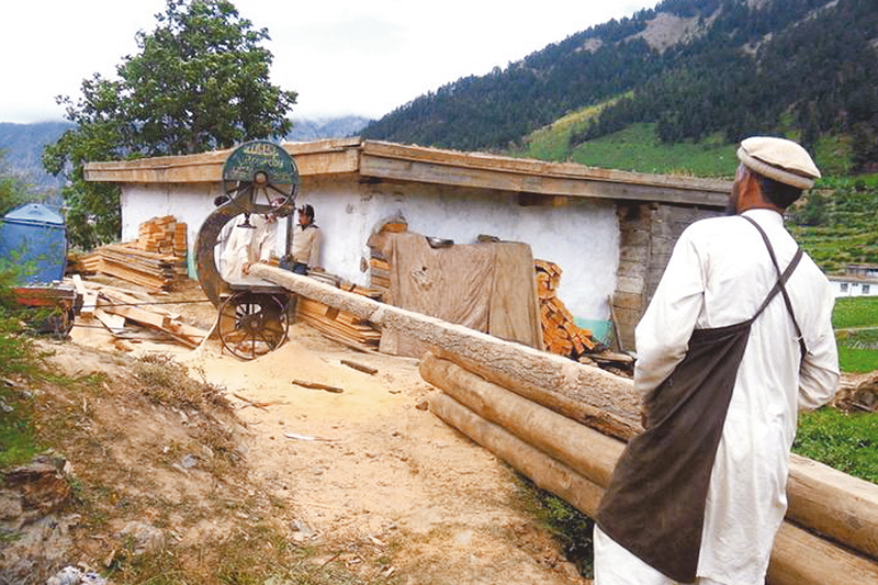 a man processes wood into planks and beams photos miangul abdullah