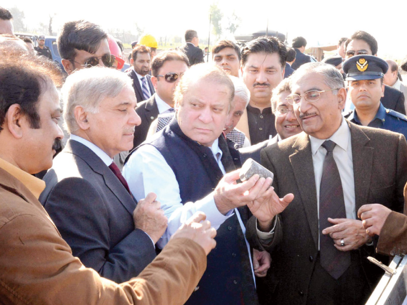 prime minister nawaz sharif and punjab cm shahbaz sharif inspect a piece of iron ore at the site of excavation in chiniot photo ppi