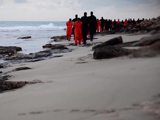 an image grab taken from a video released by is militant media arm al hayat media centre on february 15 2015 purportedly shows black clad islamic state is group fighters leading handcuffed hostages said to be egyptian coptic christians wearing orange jumpsuits before their alleged decapitation on a seashore in the libyan capital of tripoli photo afp