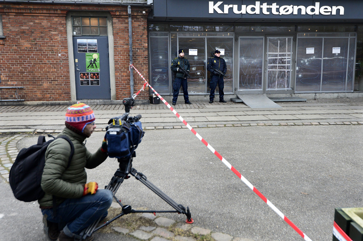 a journalist is pictured l as danish police guards stand at the entrance of the cultural center krudttonden in copenhagen denmark on february 16 2016 photo afp