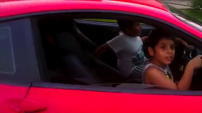 a screengrab of his 9 year old son driving a ferrari from a video posted online