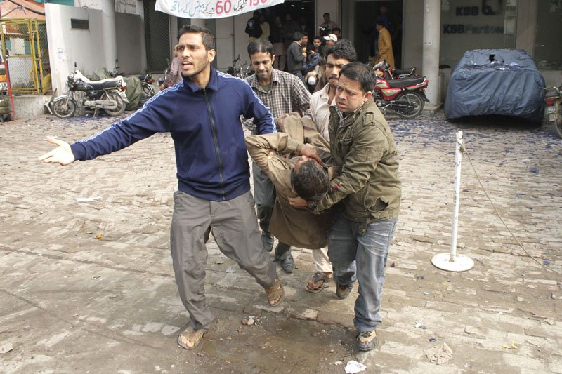 policemen rescue 1122 workers and media people arrive at the terrorism scene following a suicide bombing top volunteers take an injured man to an ambulance above photo shafiq malik express