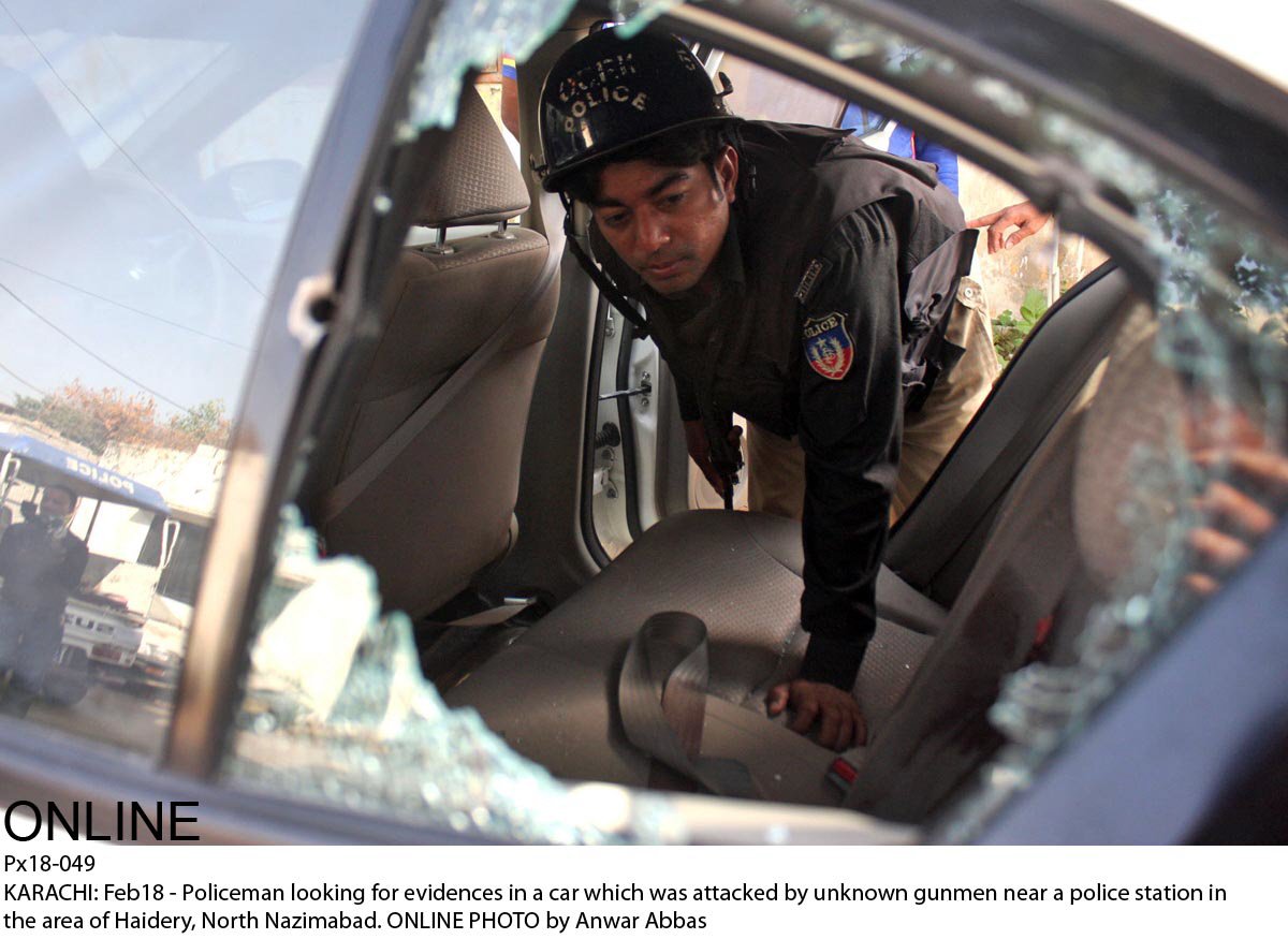 a policeman inspects the car in which karim hashwani was targeted on wednesday photo online