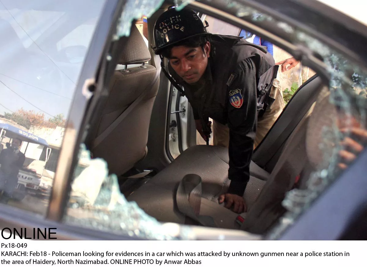 a policeman inspects the car in which karim hashwani was targeted on wednesday photo online a policeman inspects the car in which karim hashwani was targeted on wednesday photo online