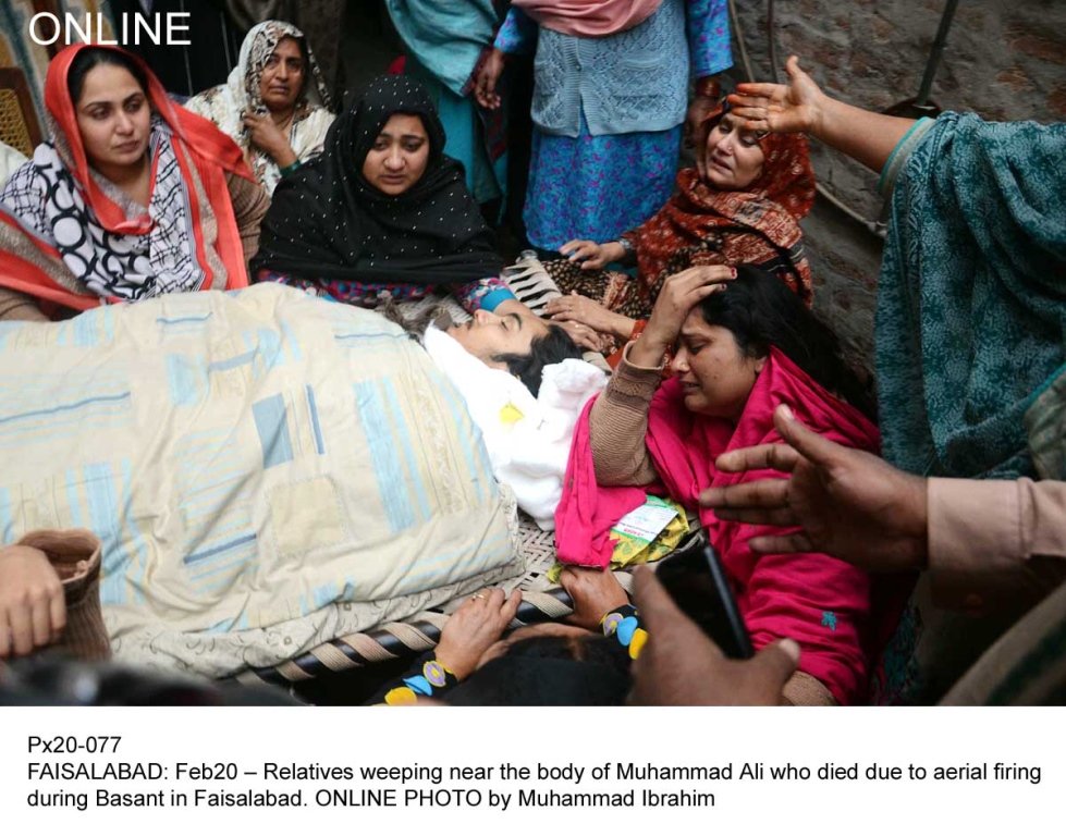 relatives weeping near the boby of muhammad ali who died due to aerial firing during basant in faisalabad photo online