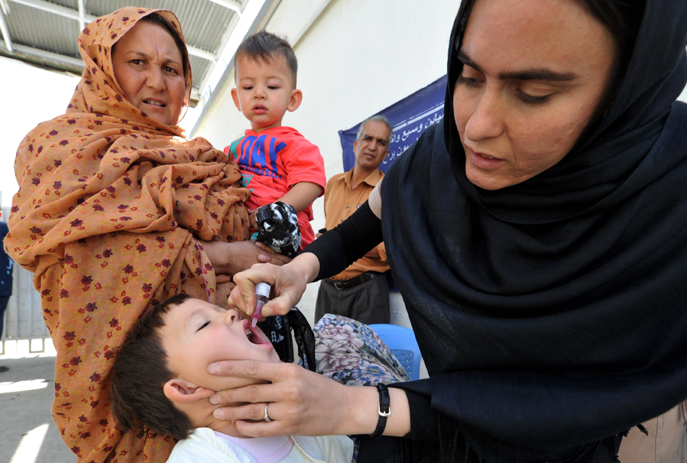 file photo of a female polio worker administering polio drops to a child photo afp