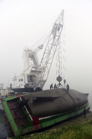 bangladeshi fire service scuba divers stand on a ferry as they try to fix wires from a crane to lift it after it capsized at paturia some 70 kms east of dhaka on february 23 2015 photo afp bangladeshi fire service scuba divers stand on a ferry as they try to fix wires from a crane to lift it after it capsized at paturia some 70 kms east of dhaka on february 23 2015 photo afp