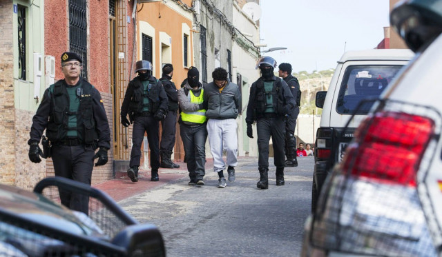 one of four people suspected of creating and operating several internet platforms spreading propaganda particularly for the islamic state group in a bid to recruit young women to join islamic state militans is arrested in melilla the spanish enclave neighbouring morocco on february 24 2015 photo afp one of four people suspected of creating and operating several internet platforms spreading propaganda particularly for the islamic state group in a bid to recruit young women to join islamic state militans is arrested in melilla the spanish enclave neighbouring morocco on february 24 2015 photo afp
