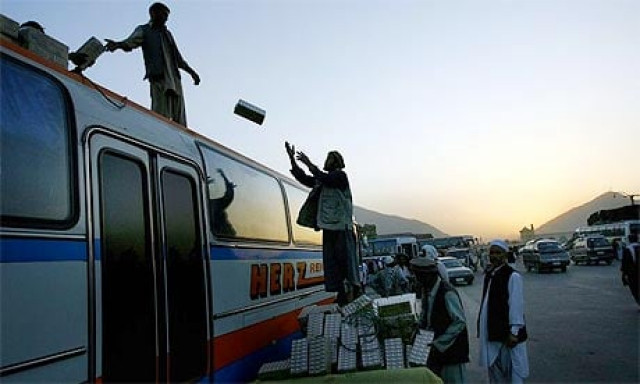 afghan men load goods onto the top of a bus in kabul photo afp afghan men load goods onto the top of a bus in kabul photo afp