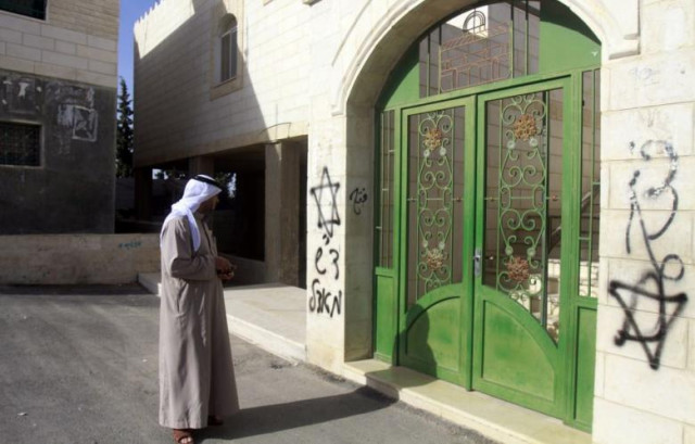 in this file photo a palestinian looks at hebrew graffiti sprayed on the walls of a mosque on 7 april 2013 in the west bank village of tuqua photo afp in this file photo a palestinian looks at hebrew graffiti sprayed on the walls of a mosque on 7 april 2013 in the west bank village of tuqua photo afp