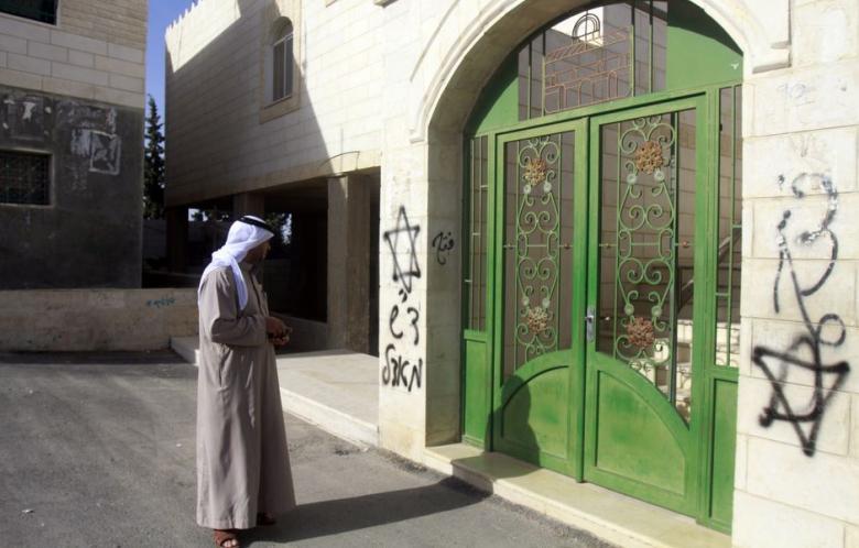 in this file photo a palestinian looks at hebrew graffiti sprayed on the walls of a mosque on 7 april 2013 in the west bank village of tuqua photo afp